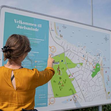 Woman pointing to a sign in Juelsminde