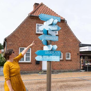 Woman pointing to a sign in Juelsminde
