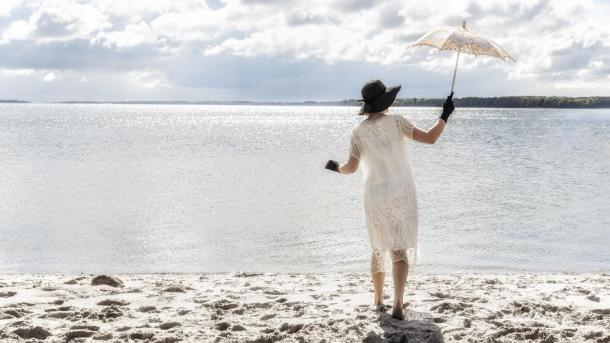 Woman holding a umbrella at Langelinie beach