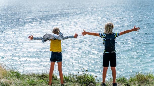 Two children standing at the coast