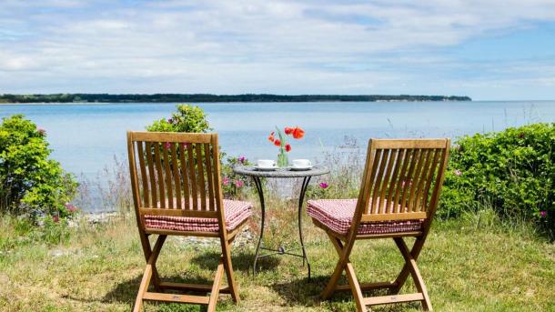 Two garden chairs and a table down to the beach in Destination Coastal Land