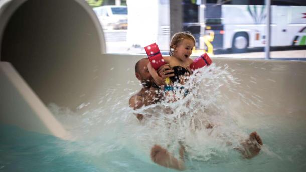 Father and daughter flying out of the water slide at Valhalla, Hou