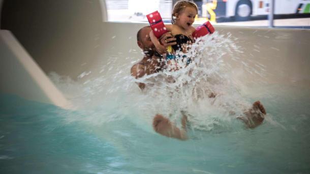 Father and daughter flying out of the water slide at Valhalla, Hou