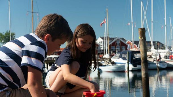 Two children catching crabs on the crabbing jetty in Juelsminde Harbour