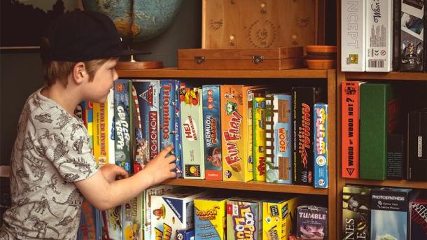 Boy choses between a lot of different games from the board games in Horsens