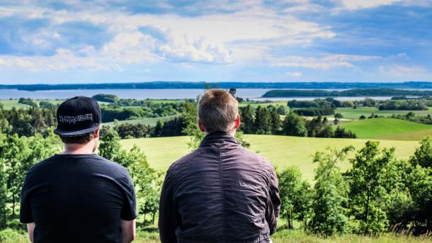 Two boys sit and enjoy the view from Trustrup Udsigtshøje