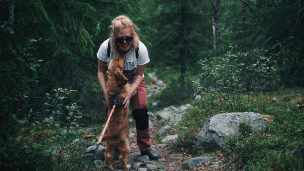 Woman hugs her dog in the forest