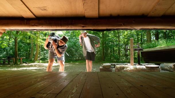 Two friends looking into a shelter in Destination Coastal Land