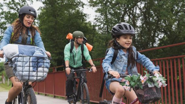 Dad, mum and daughter on a bicycle trip on the Bryrup Railway Path at The Uncovered Bridge in the Coastal Land 