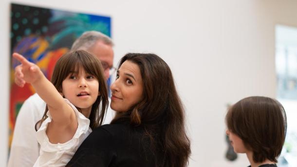pige peger mod et billede på Horsens Kunstmuseum i Kystlandet, mens hun hænger på hendes mor. 