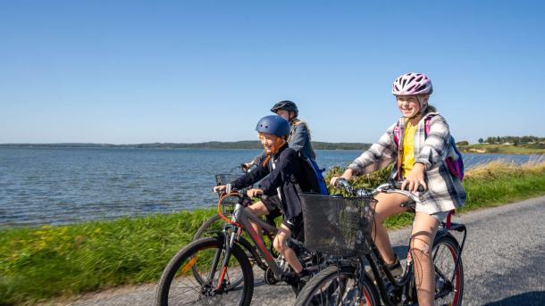 FAmilie med to børn cykler på Alrødæmningen