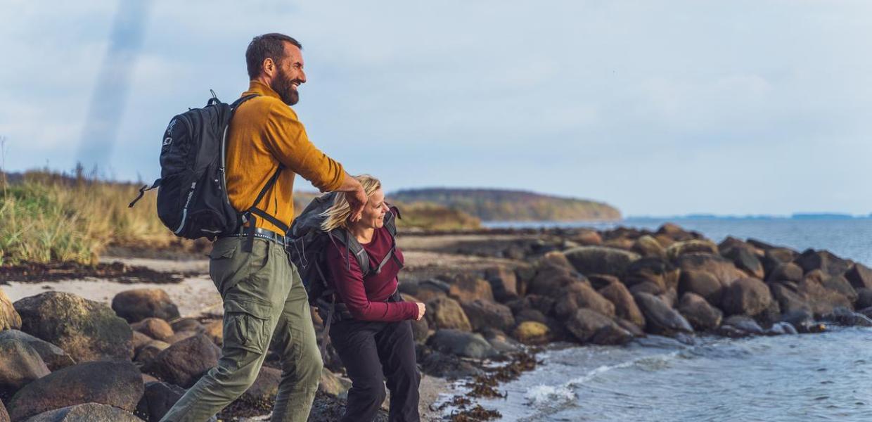 Two hikers skip stones at Horsens Fjord