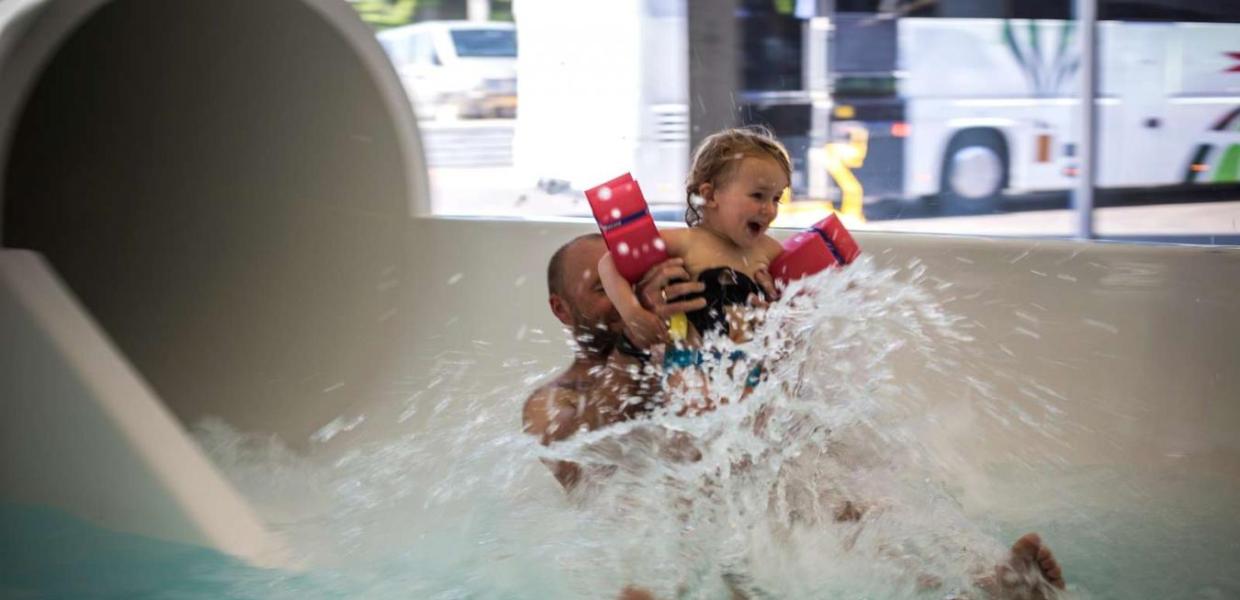 Father and daughter flying out of the water slide at Valhalla, Hou