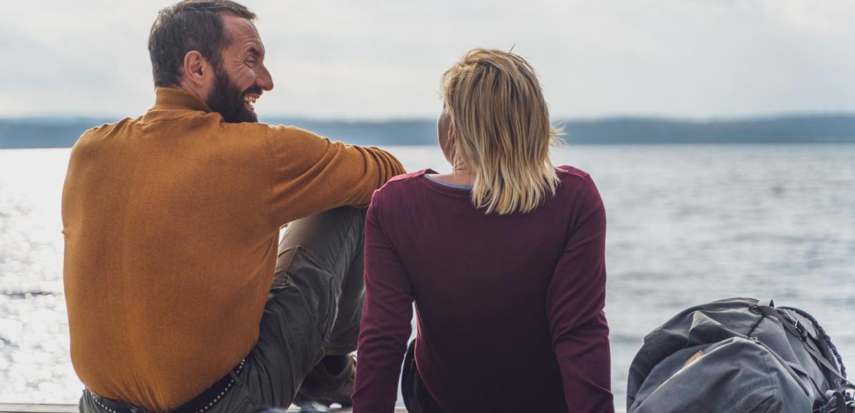 Par sidder og griner ved vandkanten ved Horsens Fjord