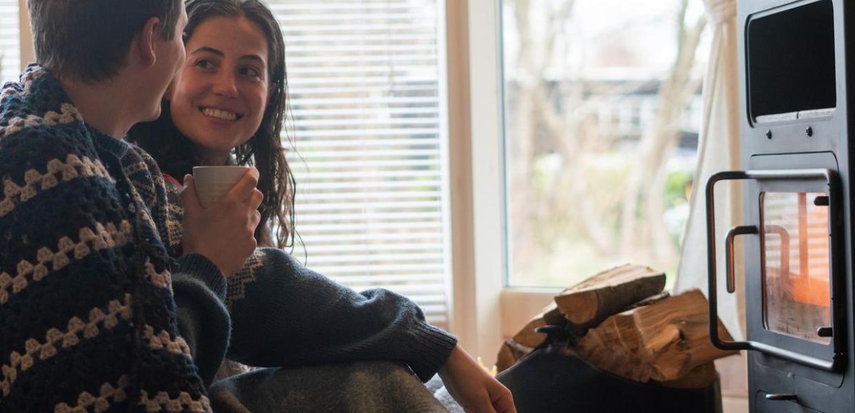 A couple on holiday in a cottage with fireplace coffee and cosiness