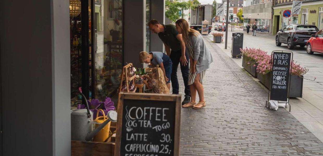 Family shopping looking at items outside a shop in Odder - part of Destination Coastal Land
