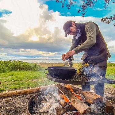 Man making food outdoor with fire