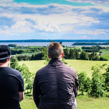 Two boys sit and enjoy the view from Trustrup Udsigtshøje