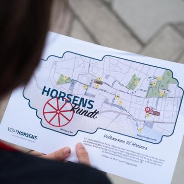 Child is holding a treasure map for the family activity "The Horsens Rundt Treasure Hunt"