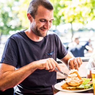 Man eating at Norsminde Fiskehus in Destination Coastal Land with the family