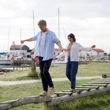 Man and woman balancing in the playground at Tunø Harbour - part of Destination Coastal Land