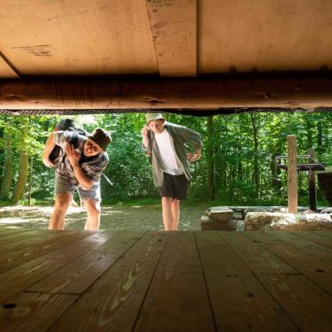 Two friends looking into a shelter in Destination Coastal Land