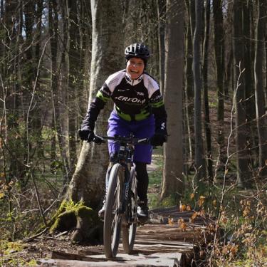 A woman riding a mountain bike on the trail in Tofte Forest in Juelsminde