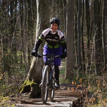 A woman riding a mountain bike on the trail in Tofte Forest in Juelsminde