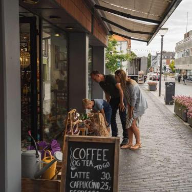 Family shopping looking at items outside a shop in Odder - part of Destination Coastal Land