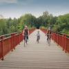 Family rides on their bikes on The Uncovered Bridge