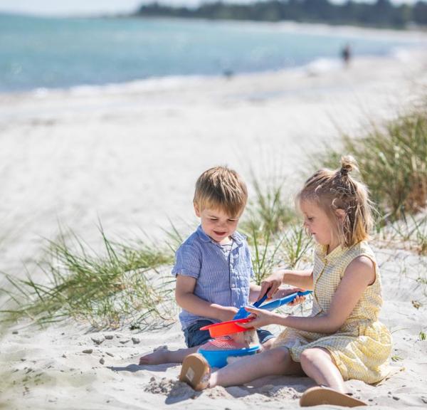 Kids are playing on the beach at Saksild