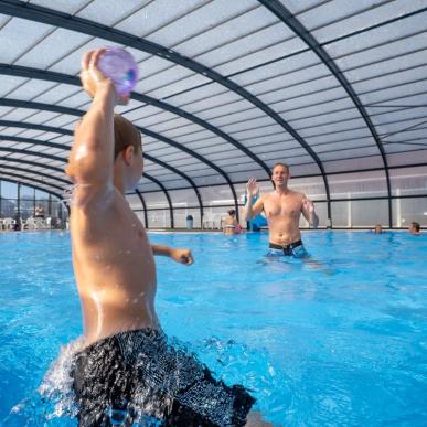 A boy and a father playing ball in a pool at Horsens City Camping near Husodde in Destination Coastal Land