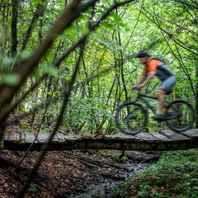 Man riding over a bridge on a mountain bike in Odder