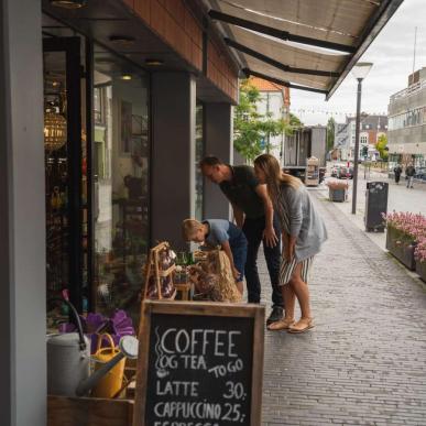 Family shopping looking at items outside a shop in Odder - part of Destination Coastal Land