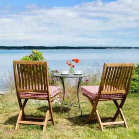 Two garden chairs and a table down to the beach in Destination Coastal Land