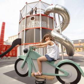 Girl sitting on a rocking motorcycle on the Industrial Museum’s playground