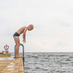 Boy standing on the jetty at Storstranden