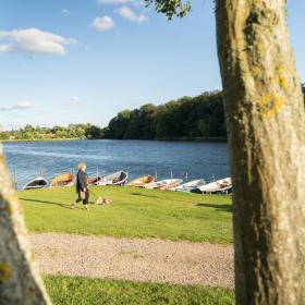 Woman walking her dog by Bygholm Lake