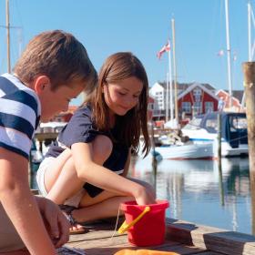 Kids with a red bucket on the marina in Juelsminde