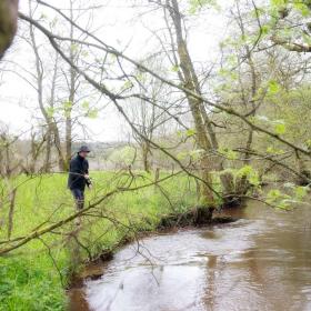 Man fishing from the banks of the river Gudenåen