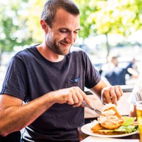 Man eating at Norsminde Fiskehus in Destination Coastal Land with the family