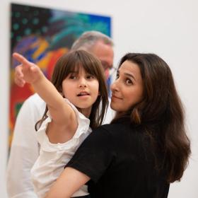 pige peger mod et billede på Horsens Kunstmuseum i Kystlandet, mens hun hænger på hendes mor. 