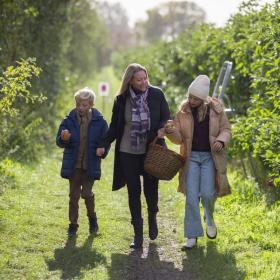 Familie på pluk selv frugt ved Karensminde Frugtplantage i Destination Kystlandet 