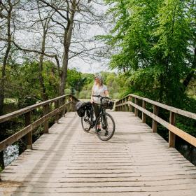 Woman stands with an electric bicycle near Gudenåen in Denmark