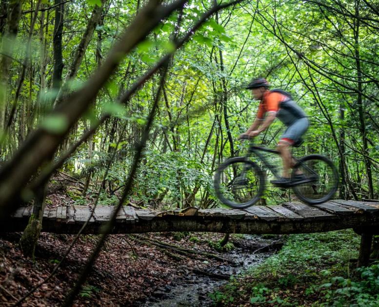 Man riding over a bridge on a mountain bike in Odder