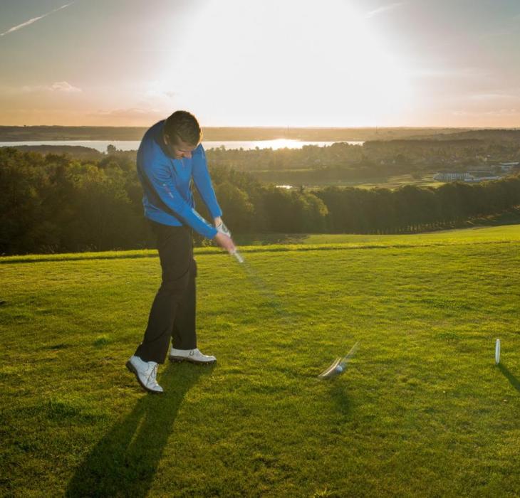 Golfer hit a golfball at Stensballegaard Golfclub in Horsens