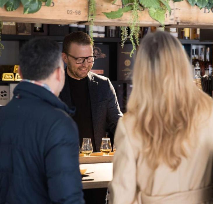 Man and lady having tastings on a shopping trip to Water of Life in Brædstrup - part of Destination Coastal Land